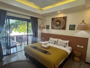 a bedroom with a large bed and a balcony at Infinity Bay Suites in Puerto Galera