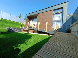 a house with a wooden deck and a lawn at Refúgio D'Aguiar in Aguiar da Beira