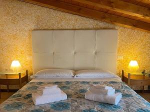 a bedroom with a large bed with towels on it at Welcome Traveller Caorsa Rooms in Cavaion Veronese