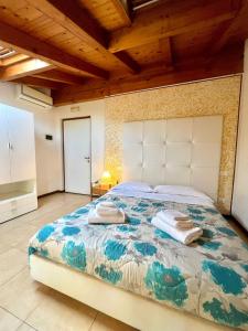 a bedroom with a large bed with towels on it at Welcome Traveller Caorsa Rooms in Cavaion Veronese +3 photos