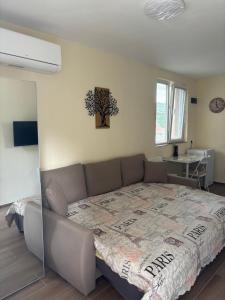a large bed in a room with a couch at Уют in Sandanski +2 photos