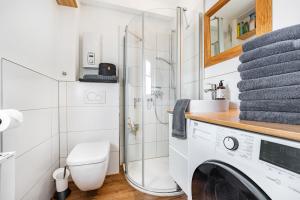 a bathroom with a shower and a washing machine at Kleines Schleihaus Lorenz in Boren +14 photos