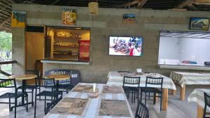 a restaurant with tables and chairs and a screen at Tctc & Camp in Shikurufumi