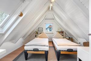 two beds in a attic bedroom with white ceilings at Kleines Schleihaus Lorenz in Boren