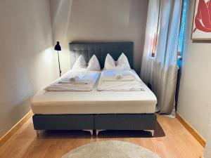 a bed with white sheets and pillows in a room at Apartment Auszeit im Ski- und Wandergebiet Spitzingsee - neu renoviert in Schliersee