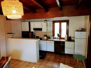 a kitchen with white cabinets and a white refrigerator at La grangette in Ajoux