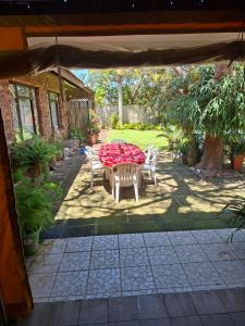 a patio with a table and chairs in a yard at The Manse in Port Shepstone