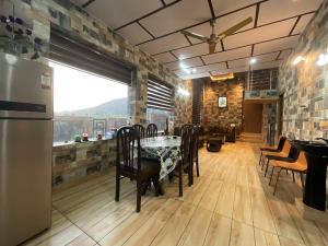a dining room with a table and chairs and a window at Casa Ramona Luxury Villa With Hot Tub Near Dharamshala Palampur in Pathyar