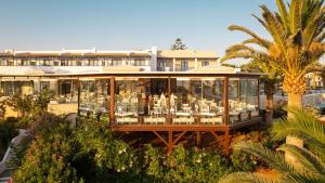a restaurant with tables and chairs in a building at Canvas by Mitsis Cretan Village in Hersonissos