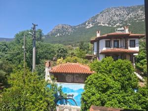 a house with a swimming pool in front of a mountain at Villa İkiz in Ula