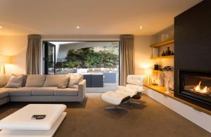 sala de estar con sofá y chimenea en Fifteen by Amazing Accom, en Queenstown