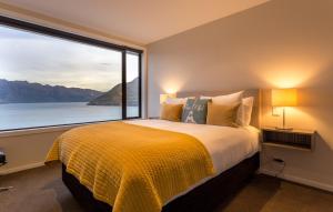 une chambre avec un grand lit avec une grande fenêtre dans l'établissement Fifteen by Amazing Accom, à Queenstown