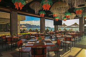 un restaurante con mesas y sillas y vistas al océano en Two Seasons Coron Bayside Hotel en Corón