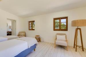 a bedroom with two beds and a chair at Quinta Javali in Aljezur
