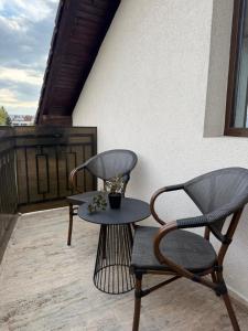 two chairs and a table on a patio at Cozy Corner Apartments in Bistriţa