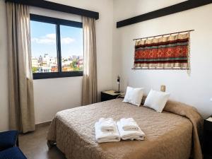 a bedroom with a bed with two towels on it at Grand Hotel by MH in Termas de Río Hondo +28 photos