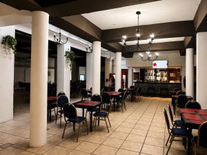 a restaurant with tables and chairs and a bar at Grand Hotel by MH in Termas de Río Hondo