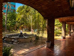 a brick building with a stone wall in a park at Grand Hotel by MH in Termas de Río Hondo