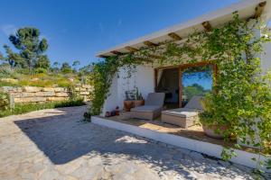 a patio of a house with a couch and ivy at Quinta Javali in Aljezur