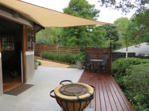 a patio with a table and chairs and an umbrella at Pumula Luxury Camps in Lions River