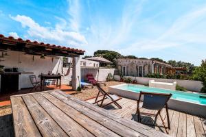 a patio with a wooden table and chairs and a pool at Cozy Suite À Da Marina in Quinta do Poço