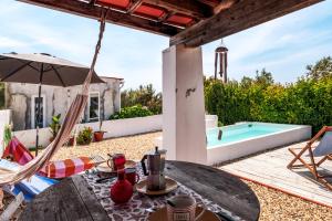 a patio with a table and chairs and a swimming pool at Cozy Suite À Da Marina in Quinta do Poço