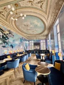 a restaurant with blue chairs and tables and a ceiling at Château Royal de Benays - Hôtel in Benais