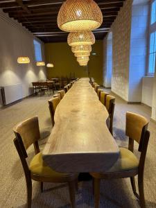 a long table in a room with chairs and lights at Château Royal de Benays - Hôtel in Benais