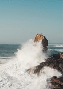 a wave crashing on a rock in the ocean at Glamping Spot - Penmarch in Penmarch +34 photos