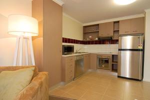 a kitchen with stainless steel appliances and a couch at Higgi Drive 3 in Mount Hotham