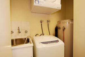a small kitchen with a sink and a washing machine at Higgi Drive 3 in Mount Hotham