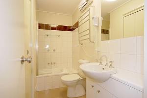 a white bathroom with a toilet and a sink at Higgi Drive 3 in Mount Hotham