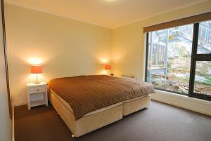 a bedroom with a bed and a large window at Higgi Drive 3 in Mount Hotham