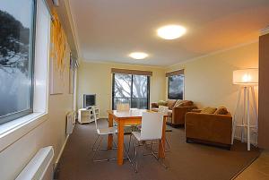 a living room with a table and a couch at Higgi Drive 3 in Mount Hotham