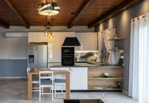 a kitchen with white cabinets and a wooden table at Apartment Vergina in Áyioi Dhéka