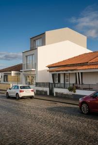 two cars parked in front of a white building at ins Ígnea in Madalena