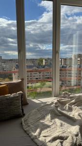 a bed in a room with a large window at Spacious modern loft on Perfetskogo in Lviv