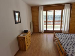 a bedroom with a bed and a dresser and a window at Torgon in Torgon