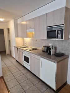 a kitchen with white cabinets and a counter top at Torgon in Torgon