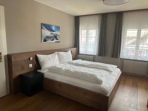 a bedroom with a bed with white sheets and pillows at Hotel Bären in Rothenburg