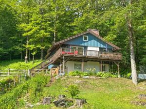 a large house with a deck on a hill at Chalet Valhalla wHot Tub in Sugarbush Village