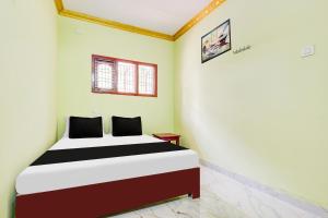 a bedroom with a bed in a room at Hotel O V Guest In in Guntūr +21 photos