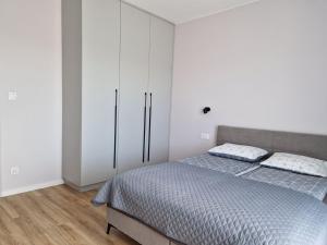 a bedroom with a bed and a white cabinet at Apartament Marzeń 13 in Kostrzyn nad Odrą