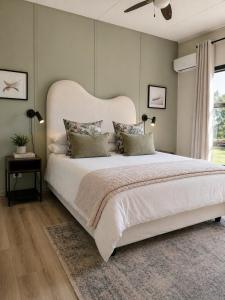 a bedroom with a large white bed and a window at Heritage View Birding Retreat in Delareyville