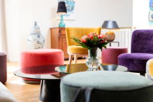 a living room with chairs and a table with a vase of flowers at Romantik Hotel Schwanefeld & Spa in Meerane