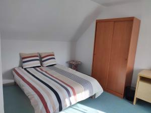 a bedroom with a bed and a wooden cabinet at Le Nid Douillet in Saint-Berthevin-sur-Vicoin