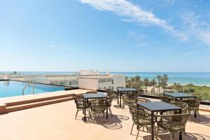 a patio with tables and chairs and the ocean at Hotel Best Village Chipiona in Costa Ballena +98 photos