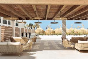 a rendering of the lobby of a resort with tables and chairs at Hotel Best Village Chipiona in Costa Ballena