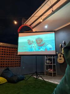 a flat screen tv in a room with a guitar at KalaKoala Hostel in Malang