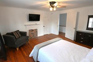 a bedroom with a bed and a chair and a television at The Sago Palm House in Thomasville